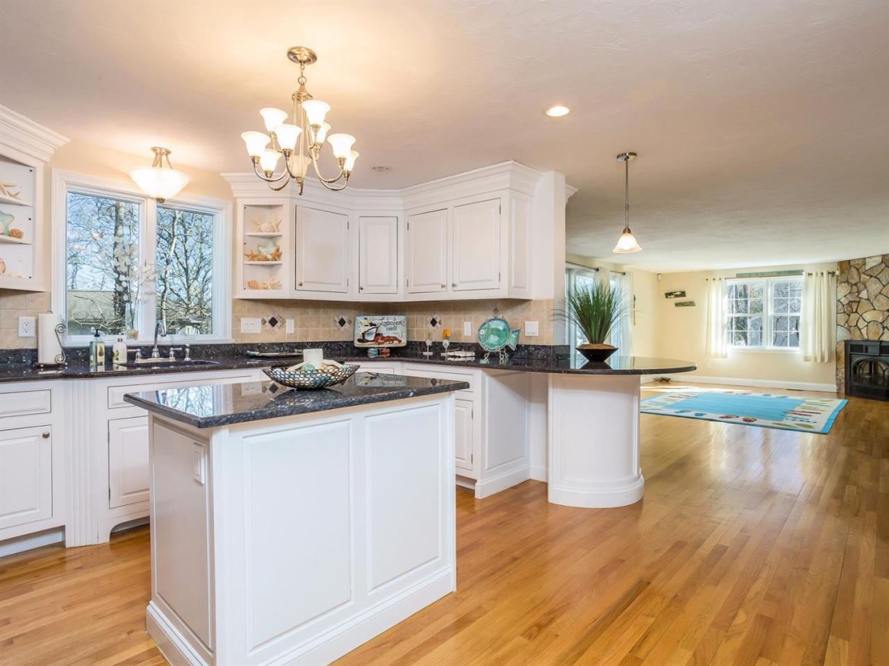 108 Fells Pond Road Mashpee, MA 02649 - Photo 8 of 35 a kitchen with kitchen island granite countertop a sink cabinets and wooden floor