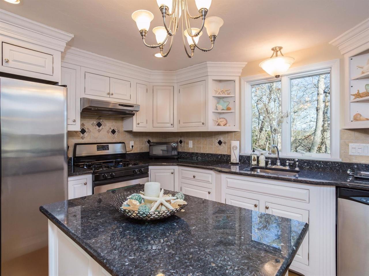 108 Fells Pond Road Mashpee, MA 02649 - Photo 10 of 35 a kitchen with stainless steel appliances granite countertop a sink a stove and a granite counter tops