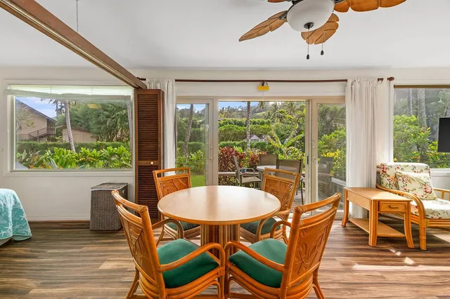 a dining room with furniture a chandelier and wooden floor