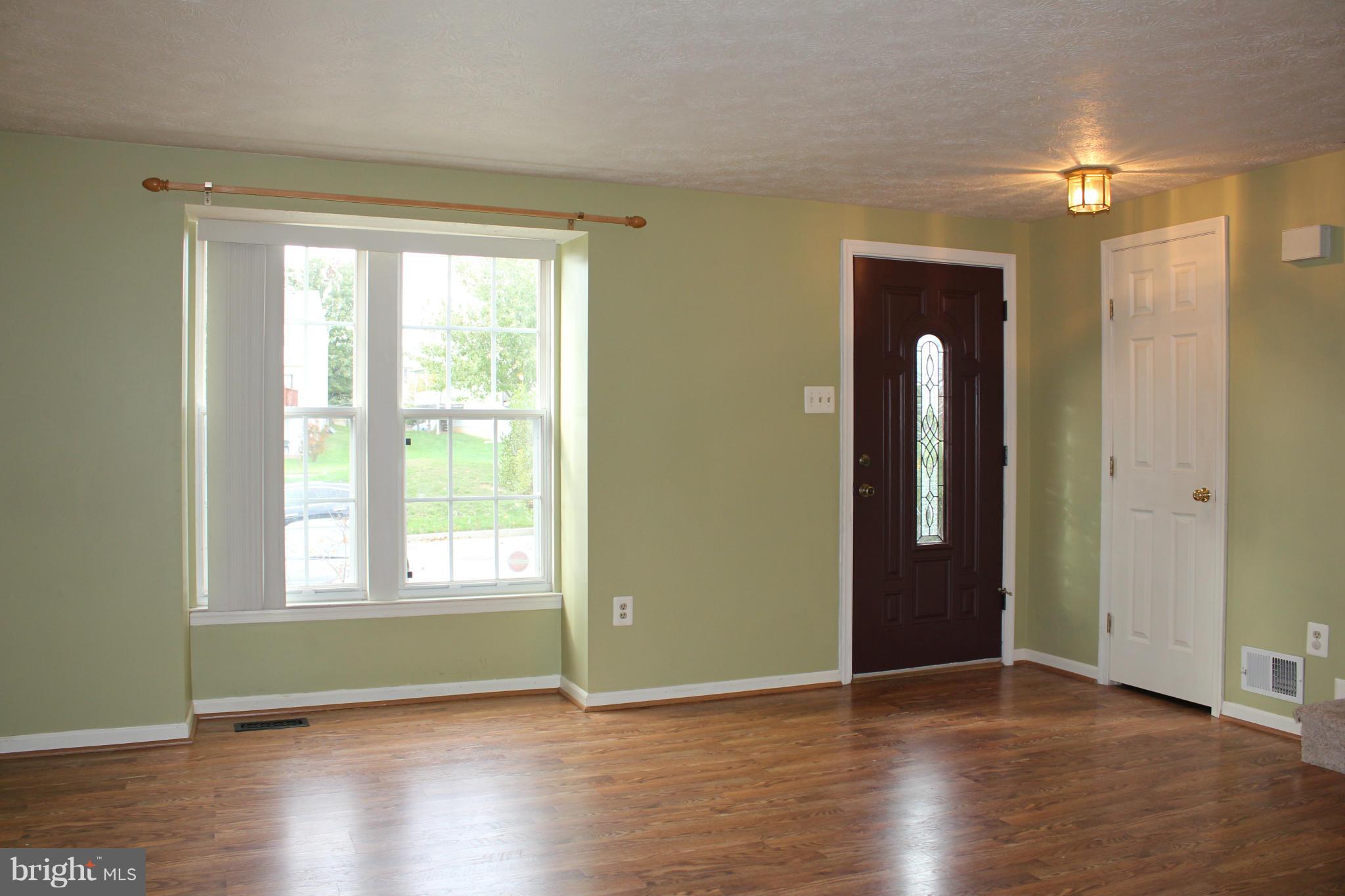 7791 Paddock Way Baltimore, MD 21244 - Photo 2 of 19 an empty room with wooden floor and windows