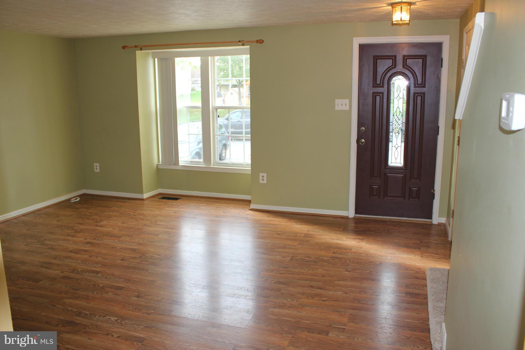 7791 Paddock Way Baltimore, MD 21244 - Photo 4 of 19 an empty room with wooden floor and windows