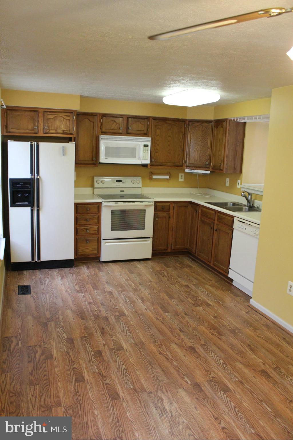 7791 Paddock Way Baltimore, MD 21244 - Photo 5 of 19 a kitchen with stainless steel appliances granite countertop a stove a sink and a refrigerator