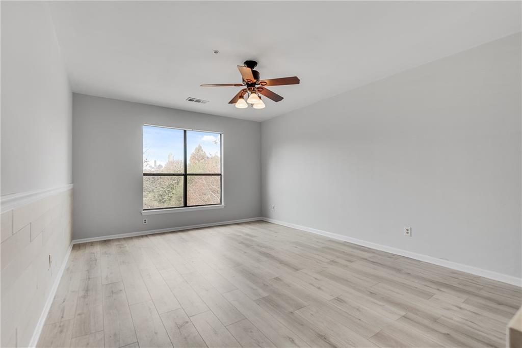 821 Ralph McGill Boulevard Northeast, Unit 3247 Atlanta, GA 30306 - Photo 12 of 43 an empty room with wooden floor ceiling fan and windows