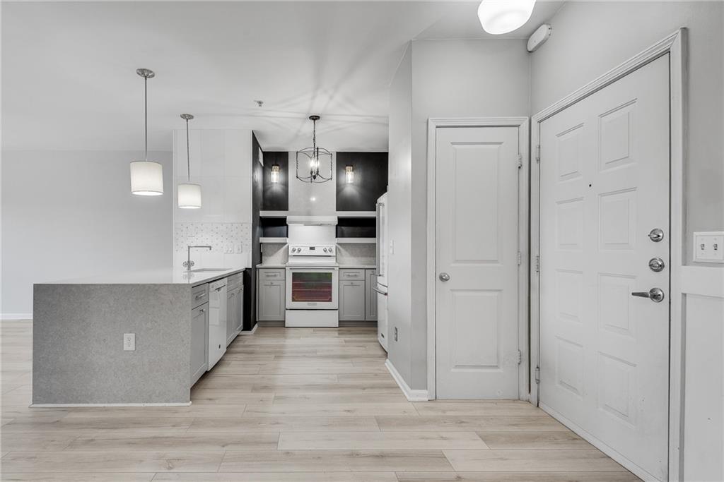 821 Ralph McGill Boulevard Northeast, Unit 3247 Atlanta, GA 30306 - Photo 16 of 43 a kitchen with stainless steel appliances kitchen island granite countertop a refrigerator and a wooden floor