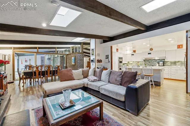 a kitchen with stainless steel appliances granite countertop a dining table chairs refrigerator and microwave