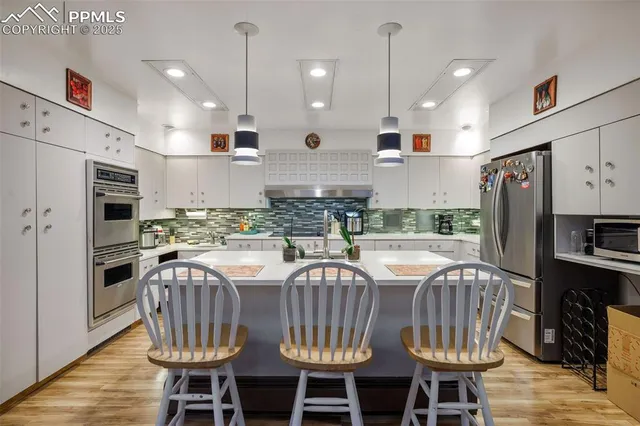 a kitchen with stainless steel appliances granite countertop a sink and a refrigerator