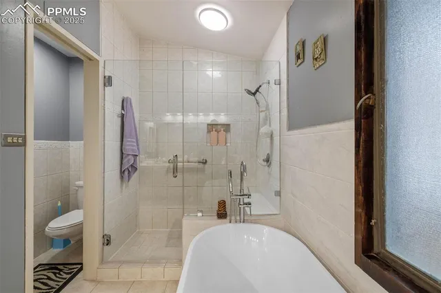 a bedroom with a bed a dresser and next to a window