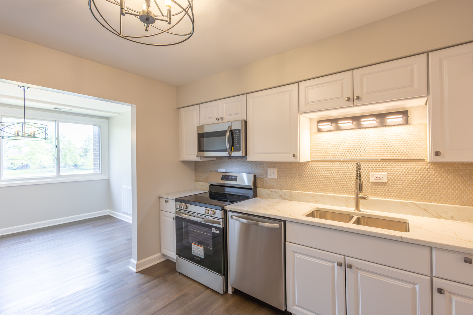 450 Raintree Court, Unit 2B Glen Ellyn, IL 60137 - Photo 10 of 28 a kitchen with stainless steel appliances granite countertop a sink a stove and a microwave