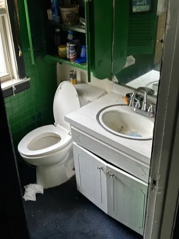 a bathroom with a toilet sink and mirror