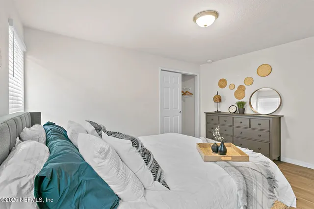 a bedroom with a bed and painting on the wall