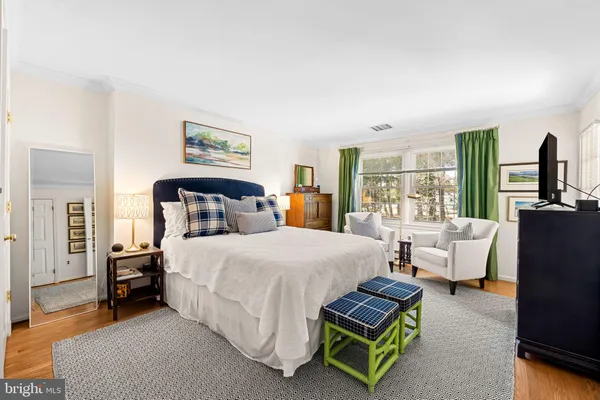 a spacious bedroom with a bed and wooden floor