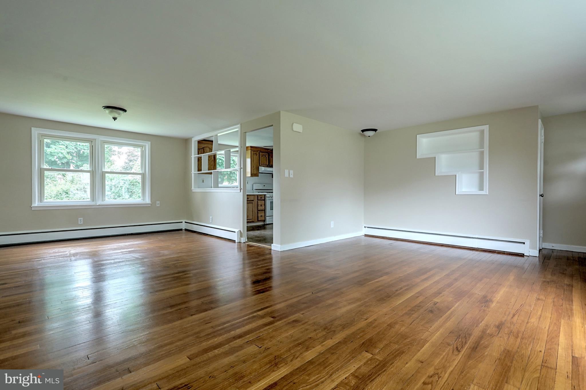 405 Edgehill Road York, PA 17403 - Photo 14 of 30 an empty room with wooden floor kitchen view and windows