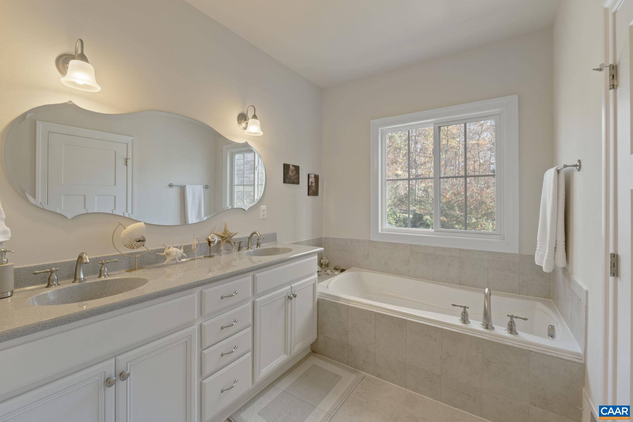 3650 Newbridge Road Keswick, VA 22947 - Photo 31 of 58 a bathroom with a tub a sink double vanity and a window