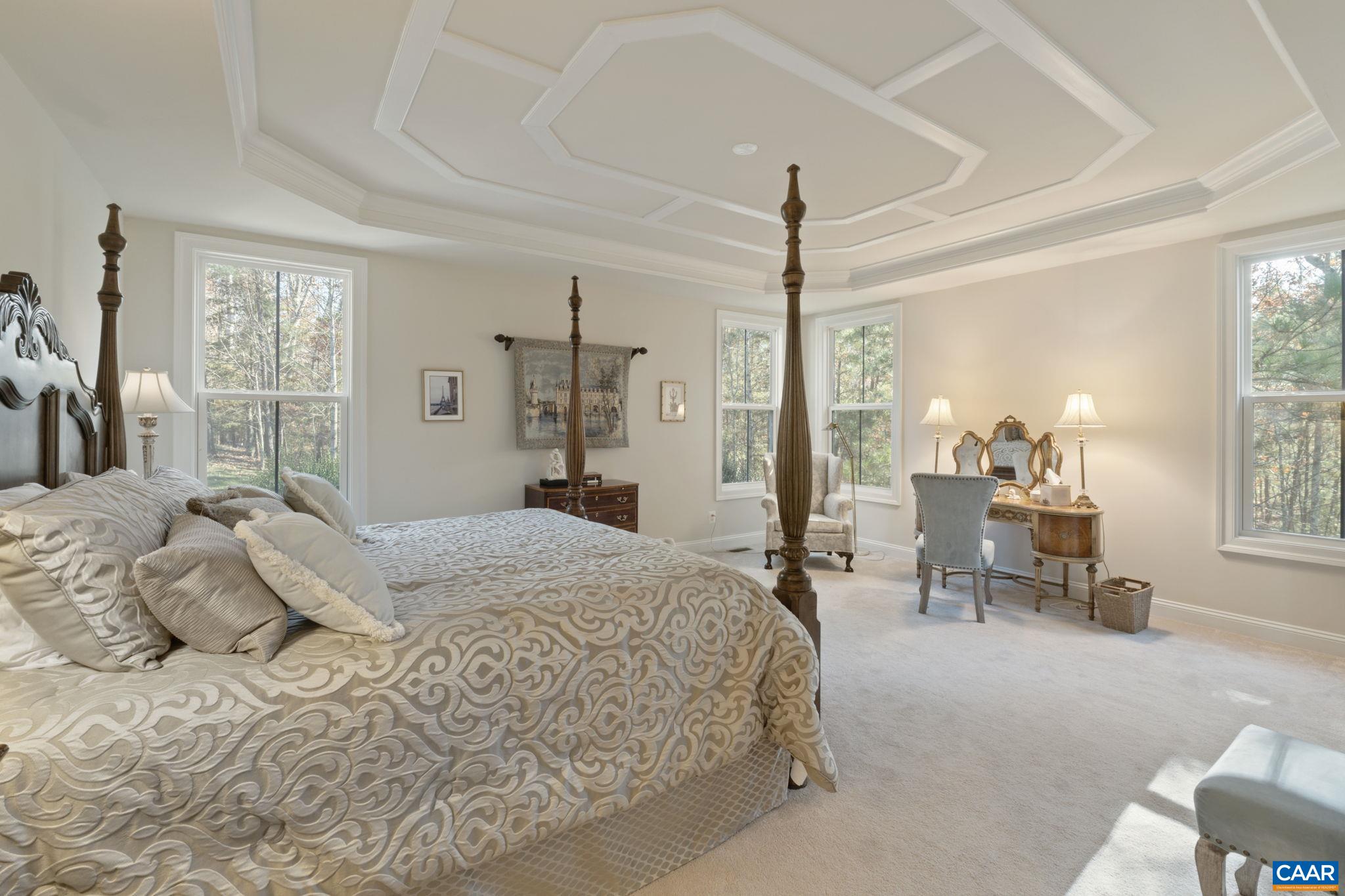 3650 Newbridge Road Keswick, VA 22947 - Photo 34 of 58 a bedroom with a large bed and a chandelier