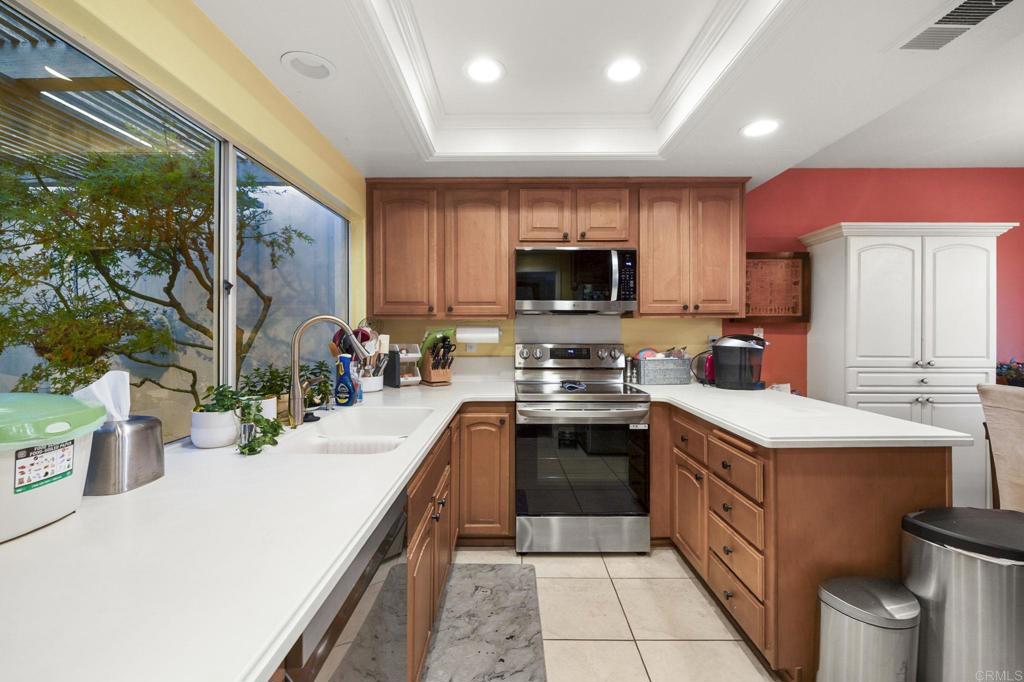 4683 Majorca Way Oceanside, CA 92056 - Photo 14 of 55 a kitchen with stainless steel appliances a stove sink microwave and cabinets