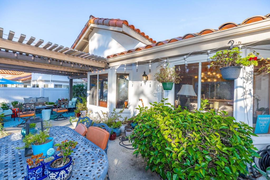 4683 Majorca Way Oceanside, CA 92056 - Photo 35 of 55 a front view of a house with outdoor seating and lots of potted plants