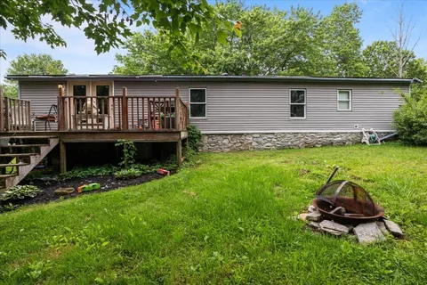 a backyard of a house with large trees and plants