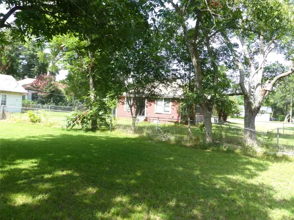 a view of yard with green space and trees around