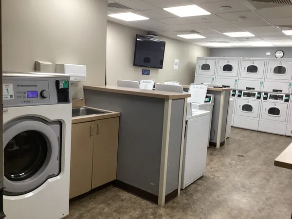a kitchen with stainless steel appliances kitchen island a table chairs microwave and sink