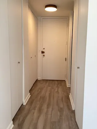 a view of a hallway with wooden floor
