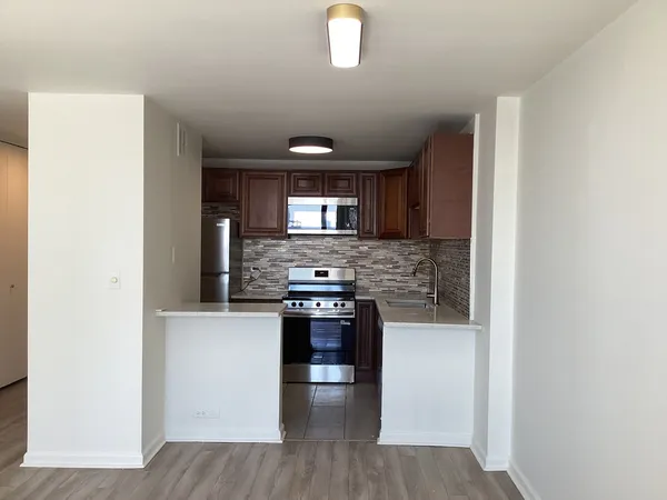 a kitchen with stainless steel appliances granite countertop a stove a sink and a refrigerator