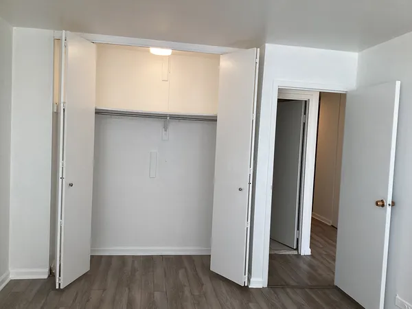 a view of an empty room with wooden floor