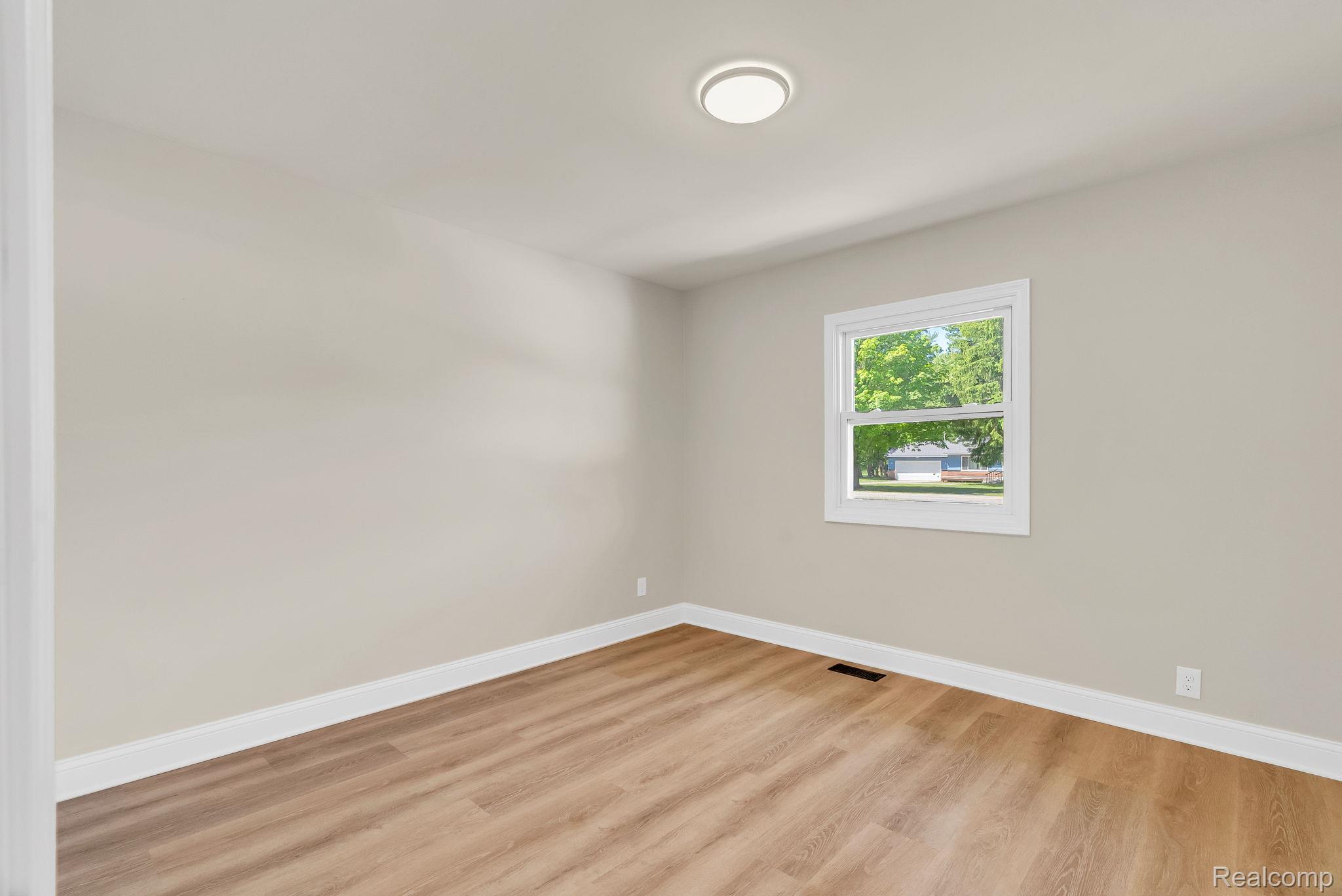 4046 State Road Fort Gratiot, MI 48059 - Photo 24 of 38 Room featuring wood-finish flooring, neutral wall paint, and white trim