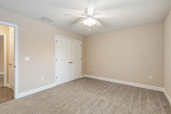 an empty room with a ceiling fan and a window