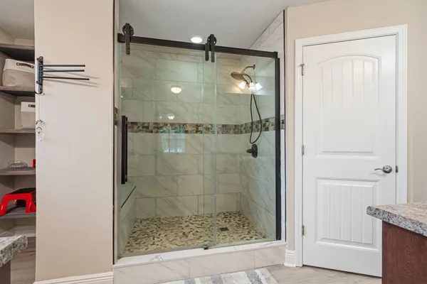 a bathroom with a glass shower door and a window