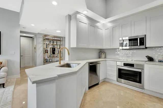 a kitchen with stainless steel appliances granite countertop a sink stove and microwave