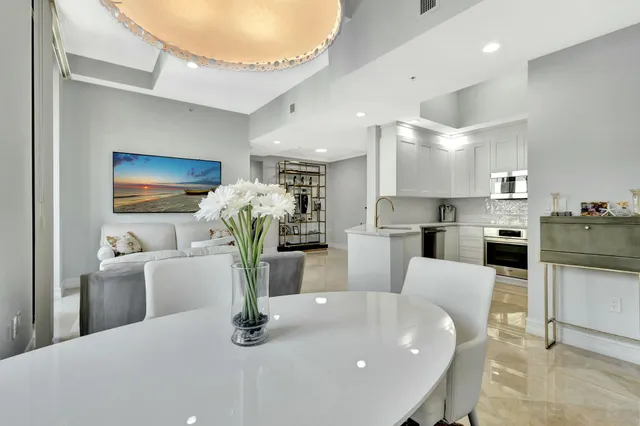 a kitchen with stainless steel appliances granite countertop a refrigerator a stove a sink dishwasher and white cabinets with wooden floor