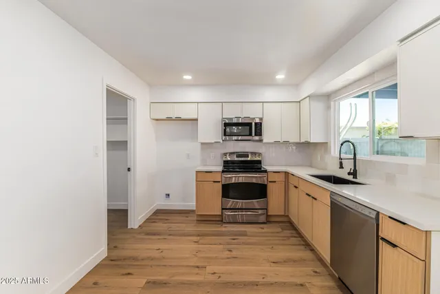 a kitchen with stainless steel appliances granite countertop a sink stove microwave and refrigerator