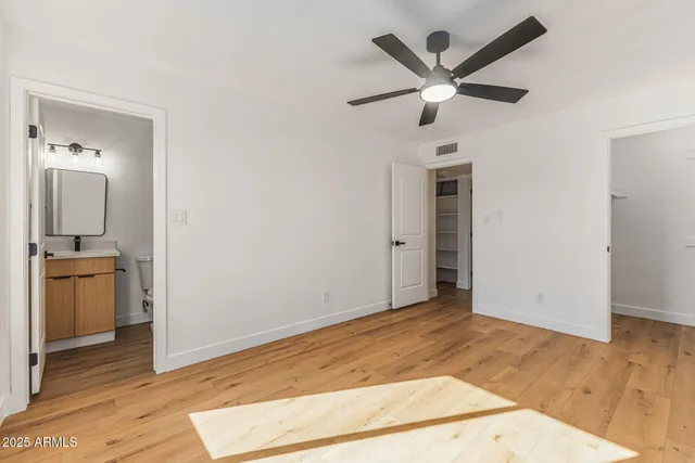 a view of a livingroom with a ceiling fan and wooden floor