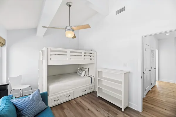 a bedroom with a bed and wooden floor