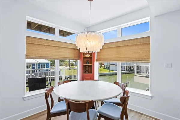 a dining room with furniture a chandelier and wooden floor