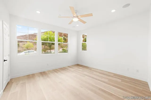 an empty room with windows and fan