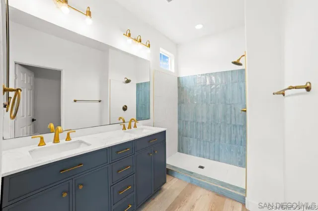 a bathroom with a double vanity sink toilet mirror and shower
