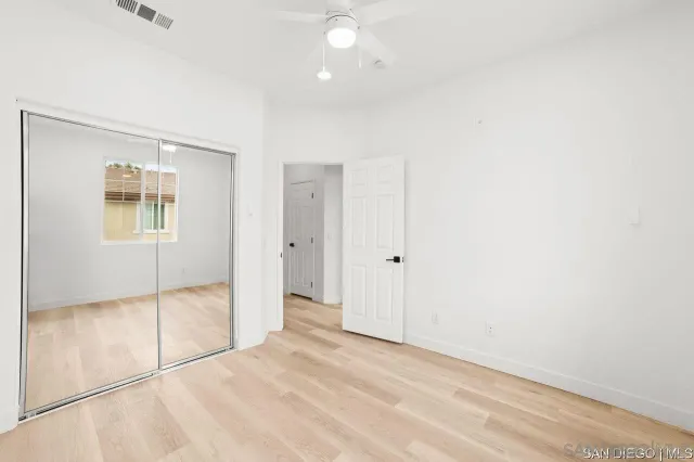 an empty room with windows and closet