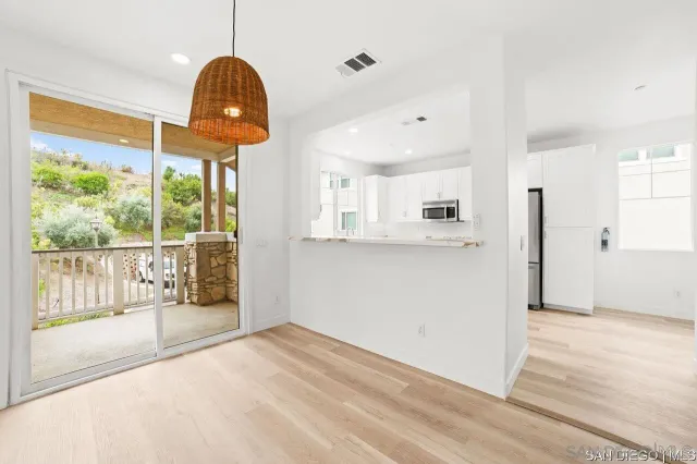 a view of a kitchen with wooden floor and windows