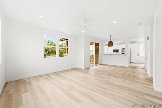 a view of empty room with wooden floor and window