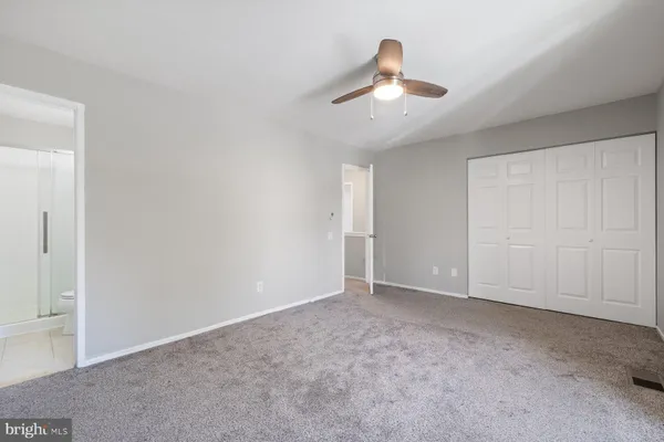 an empty room with chandelier fan