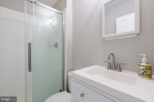 a bathroom with a sink a toilet and shower