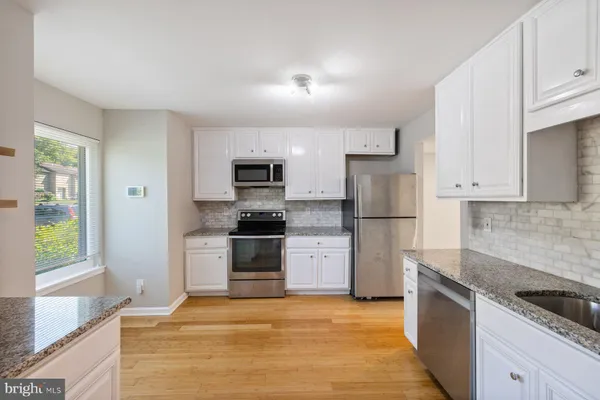 a kitchen with stainless steel appliances granite countertop a refrigerator sink and stove
