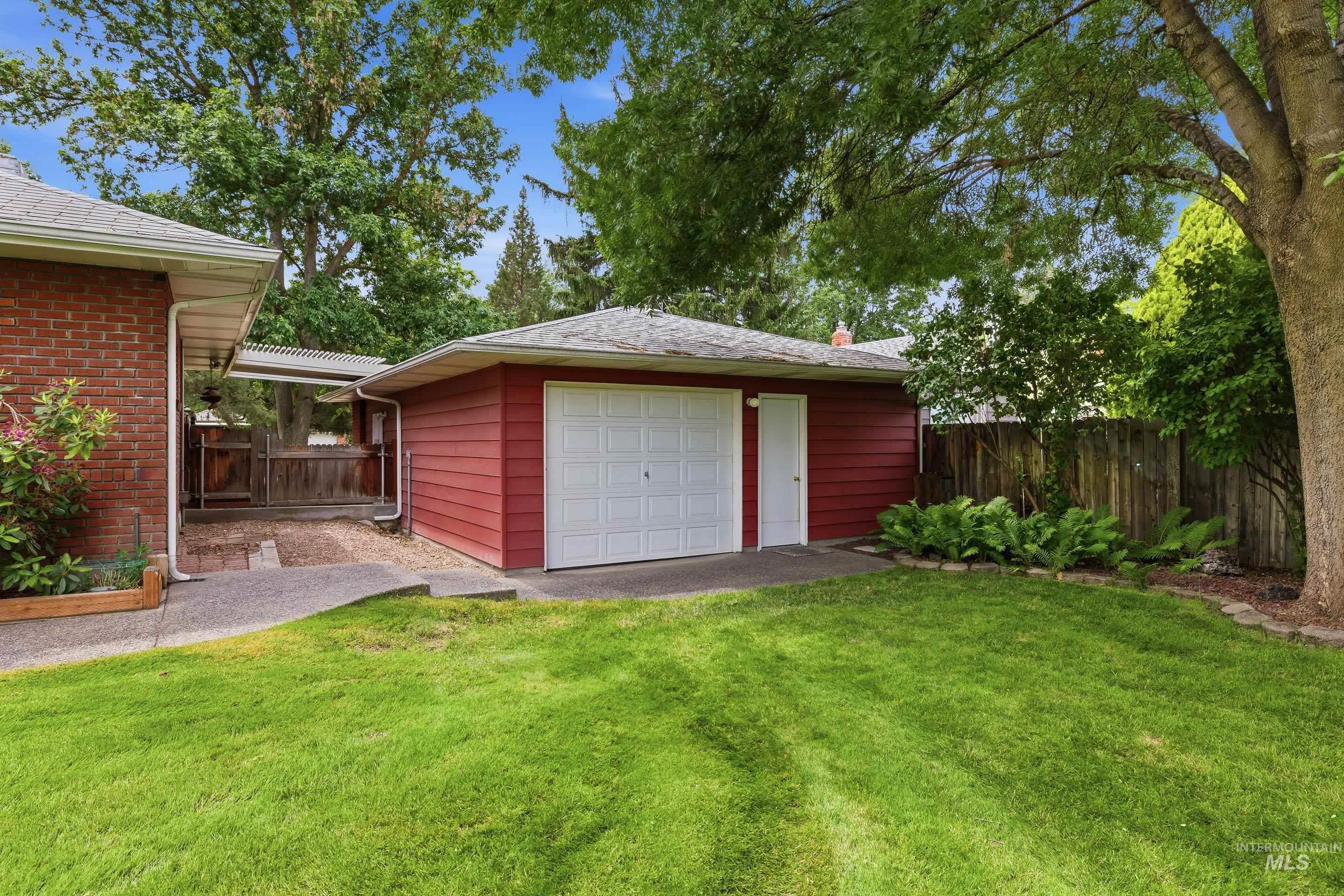 504 West Howe Street Boise, ID 83706 - Photo 46 of 47 Detached garage with red siding and white overhead door, concrete driveway, and a separate entry door