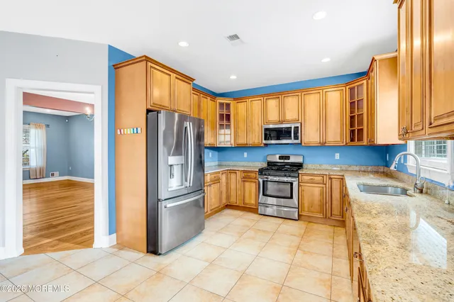 a kitchen with stainless steel appliances granite countertop a sink and dishwasher with cabinets next to a window