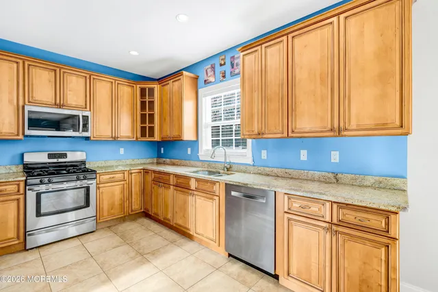 a view of kitchen with stainless steel appliances granite countertop a stove and a refrigerator