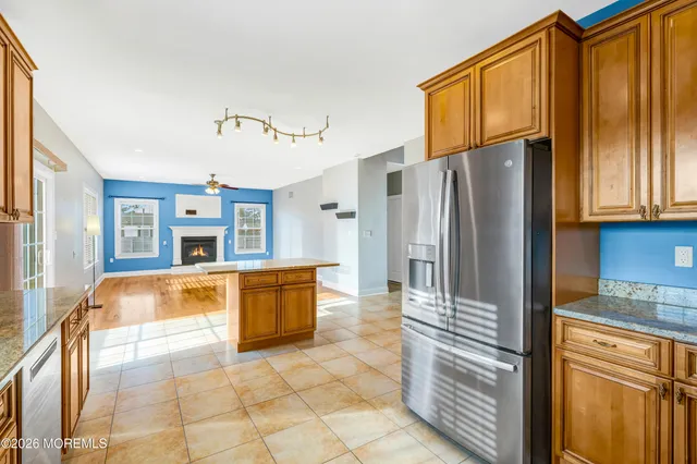 a view of an empty room with wooden floor fireplace and a window