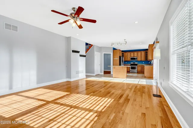 a view of a room with wooden floor and windows