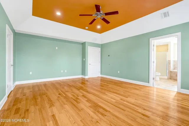 a spacious bathroom with a granite countertop sink a toilet a mirror and bathtub