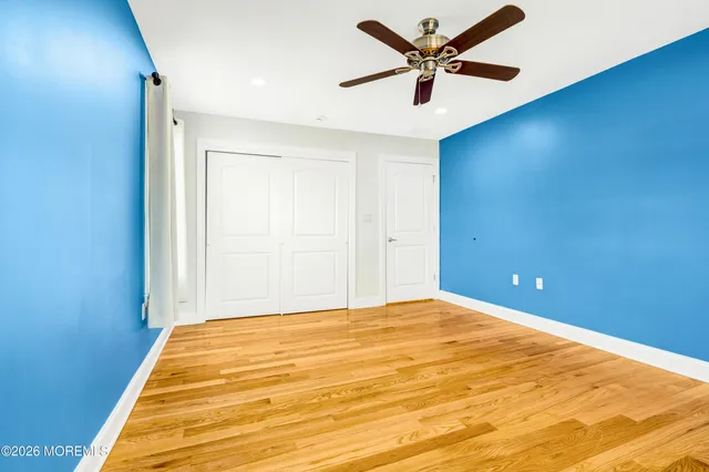 a view of a big room with wooden floor and a ceiling fan